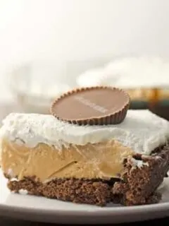 A slice of peanut butter pie with brownie crust garnished with a peanut butter cup.