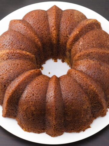 Whole spiced bundt cake on a white round dinner plate.
