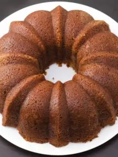 Whole spiced bundt cake on a white round dinner plate.
