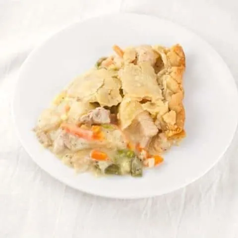 a slice of prepared turkey pot pie on a round white plate