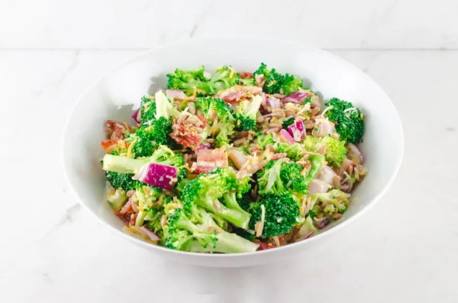 broccoli salad with bacon and cheese ready to eat in white bowl