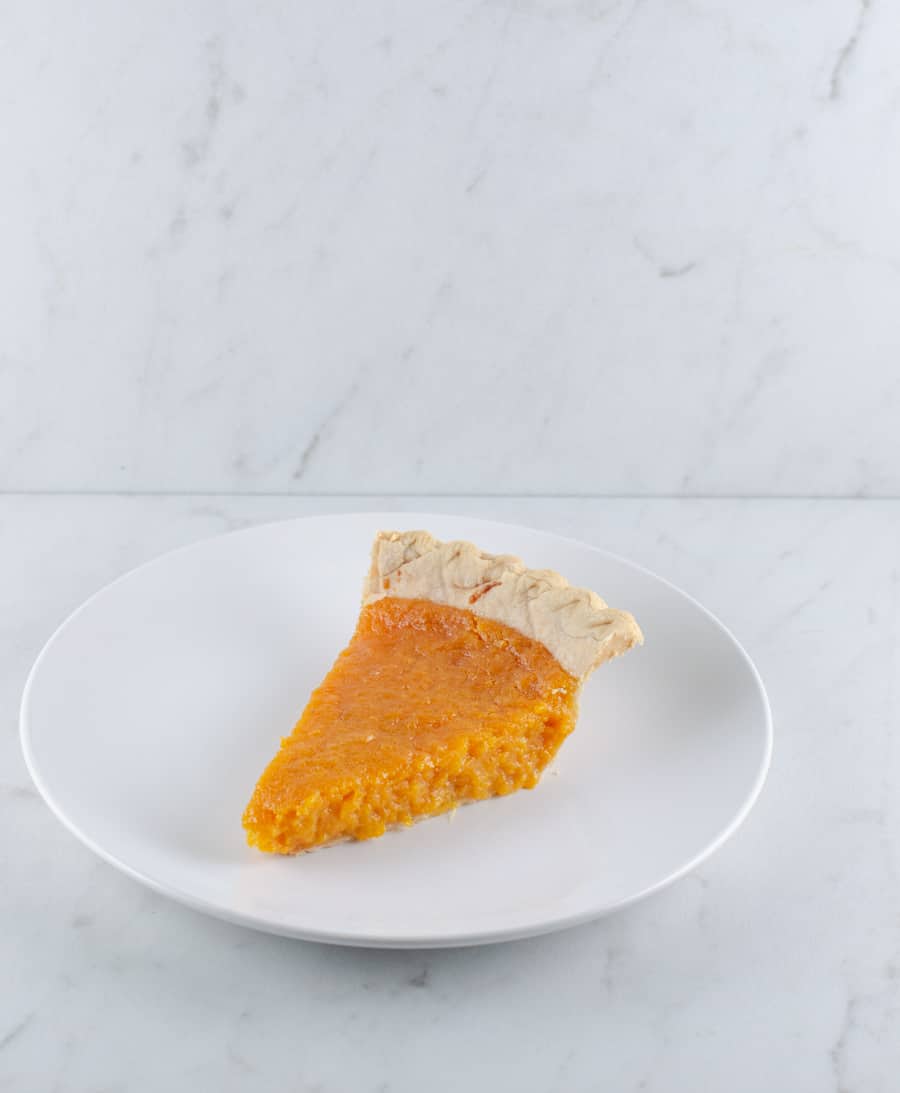 The Best Sweet Potato Pie Recipe picture of a slice on a white plate ready to eat