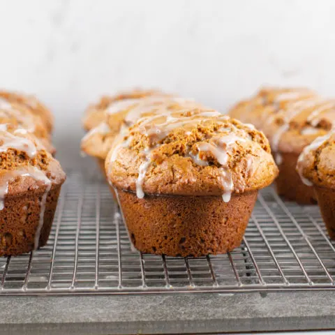 Glazed gingerbread muffins on a cooling rack.