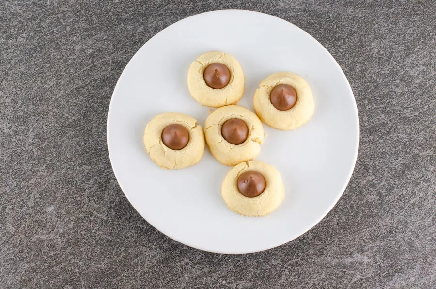 https://smartsavvyliving.com/wp-content/uploads/2019/12/Shortbread-Hershey-Kiss-Cookies-Recipe-picture-just-baked-cookies-with-kiss-on-plate-overhead-1.jpg.webp