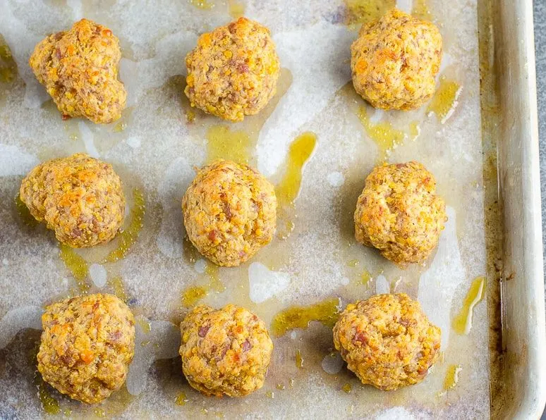 Sausage balls without Bisquick after they have been baked, still on the parchment lined baking sheet.