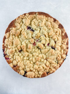 Whole round German plum cake on a concrete background