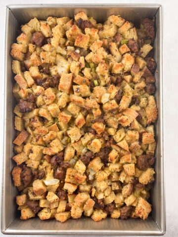 baked sausage and sourdough stuffing in a metal 9 by 13 pan ready to be served.