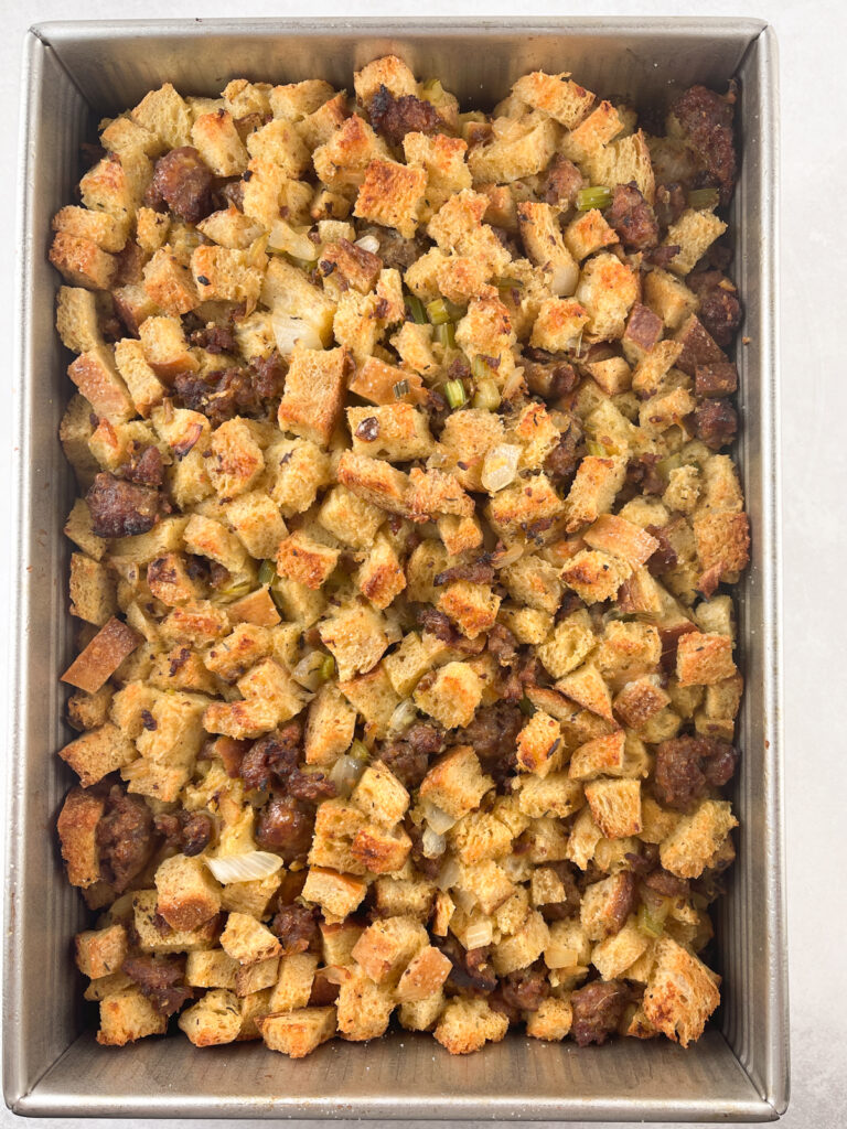 baked sausage and sourdough stuffing in a metal 9 by 13 pan ready to be served