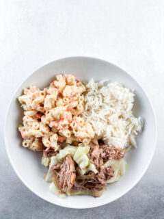 Traditional Hawaiian plate lunch in a white round bowl: white rice, macaroni salad, and kalua pork and cabbage.