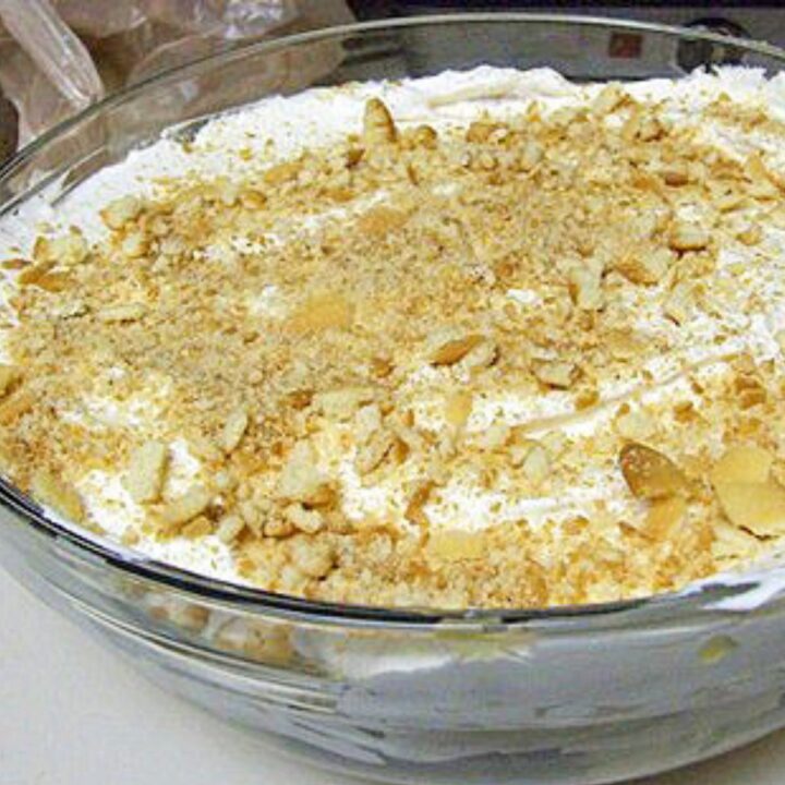 finished southern banana pudding with nilla wafer crumbs on top in a large glass bowl