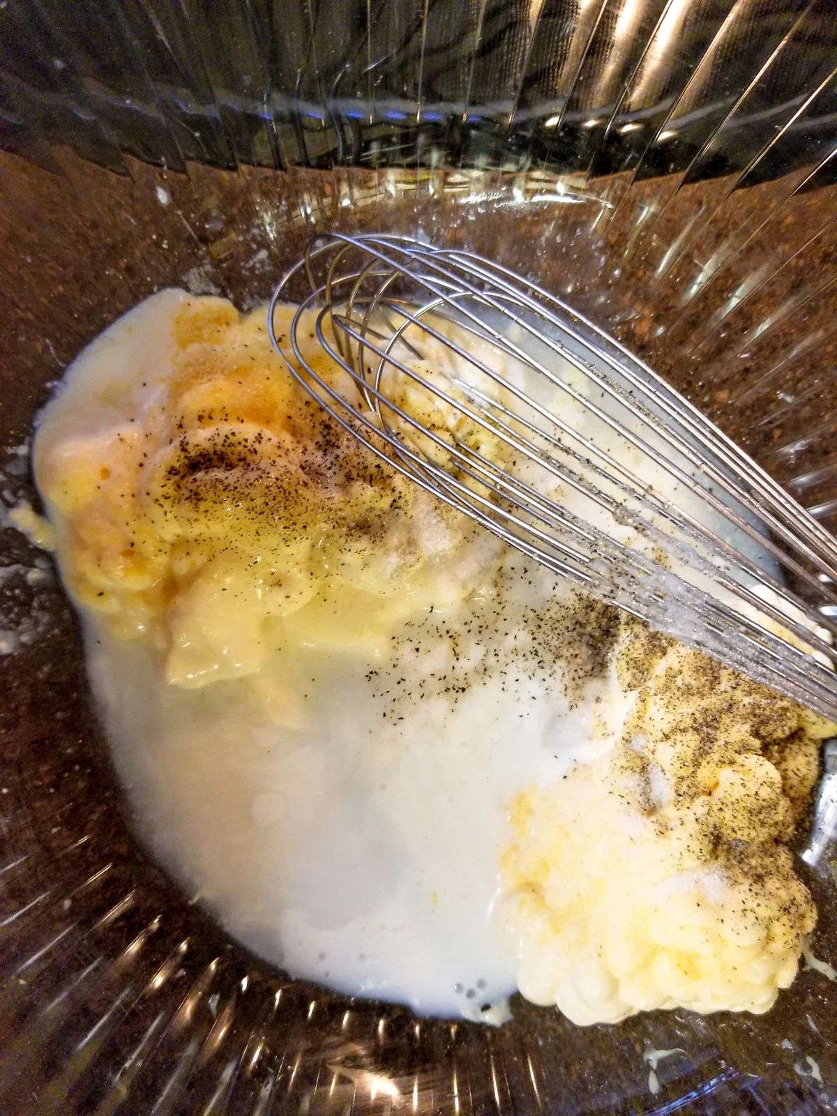 Mayo, buttermilk, sugar, vinegar, salt, pepper, and garlic powder in a mixing bowl ready to be whisked together.