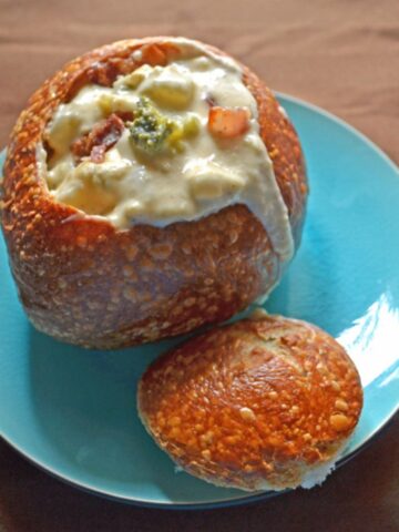 Broccoli, bacon, and potato chowder with cheese in a bread bowl