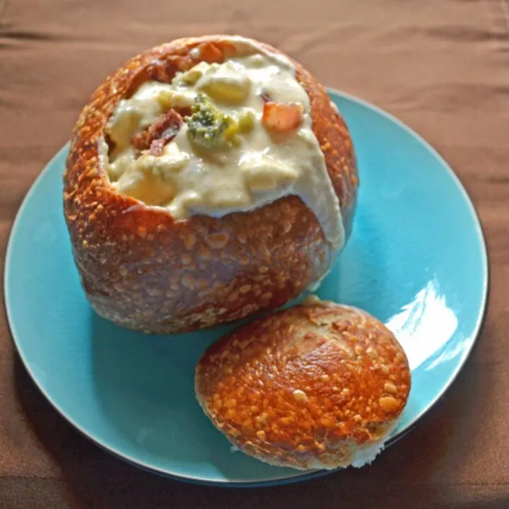 Broccoli, bacon, and potato chowder with cheese in a bread bowl