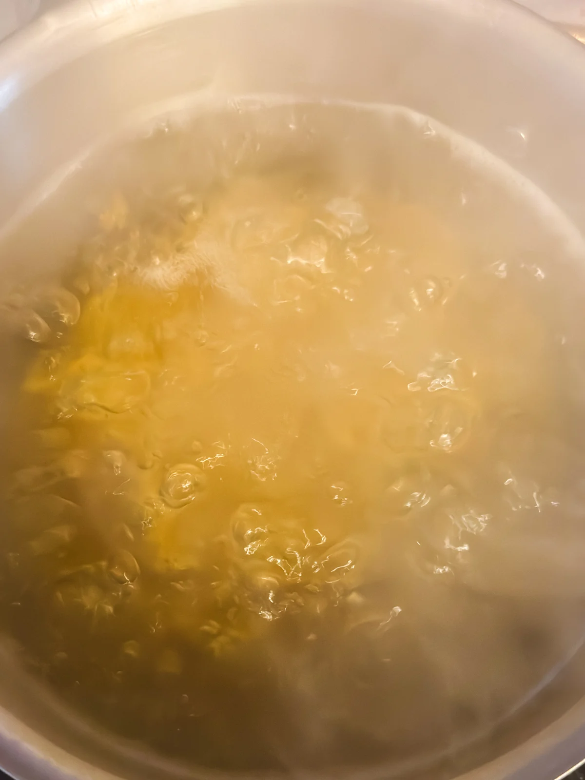 Boing macaroni in a stainless steel pot.