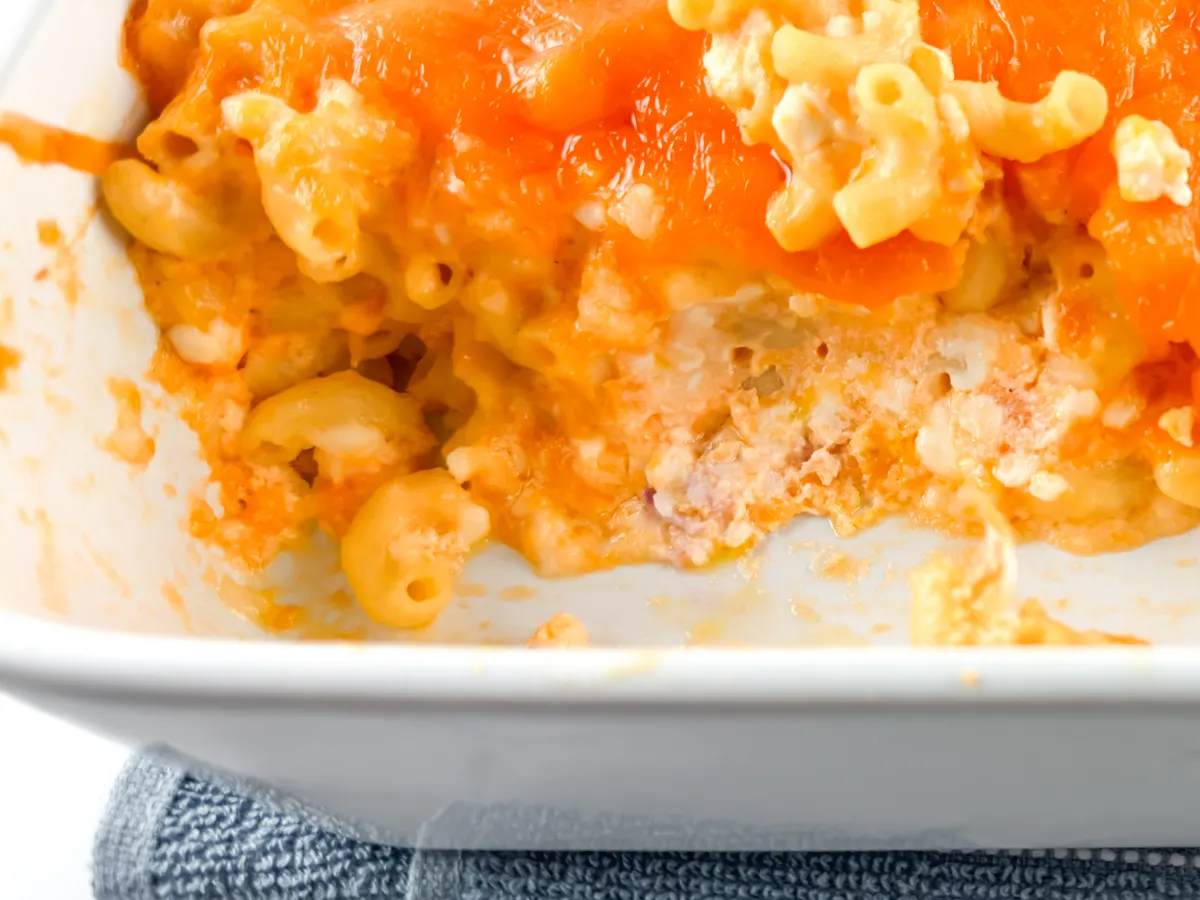 Close up of baked mac and cheese after some has been taken out of the baking dish.