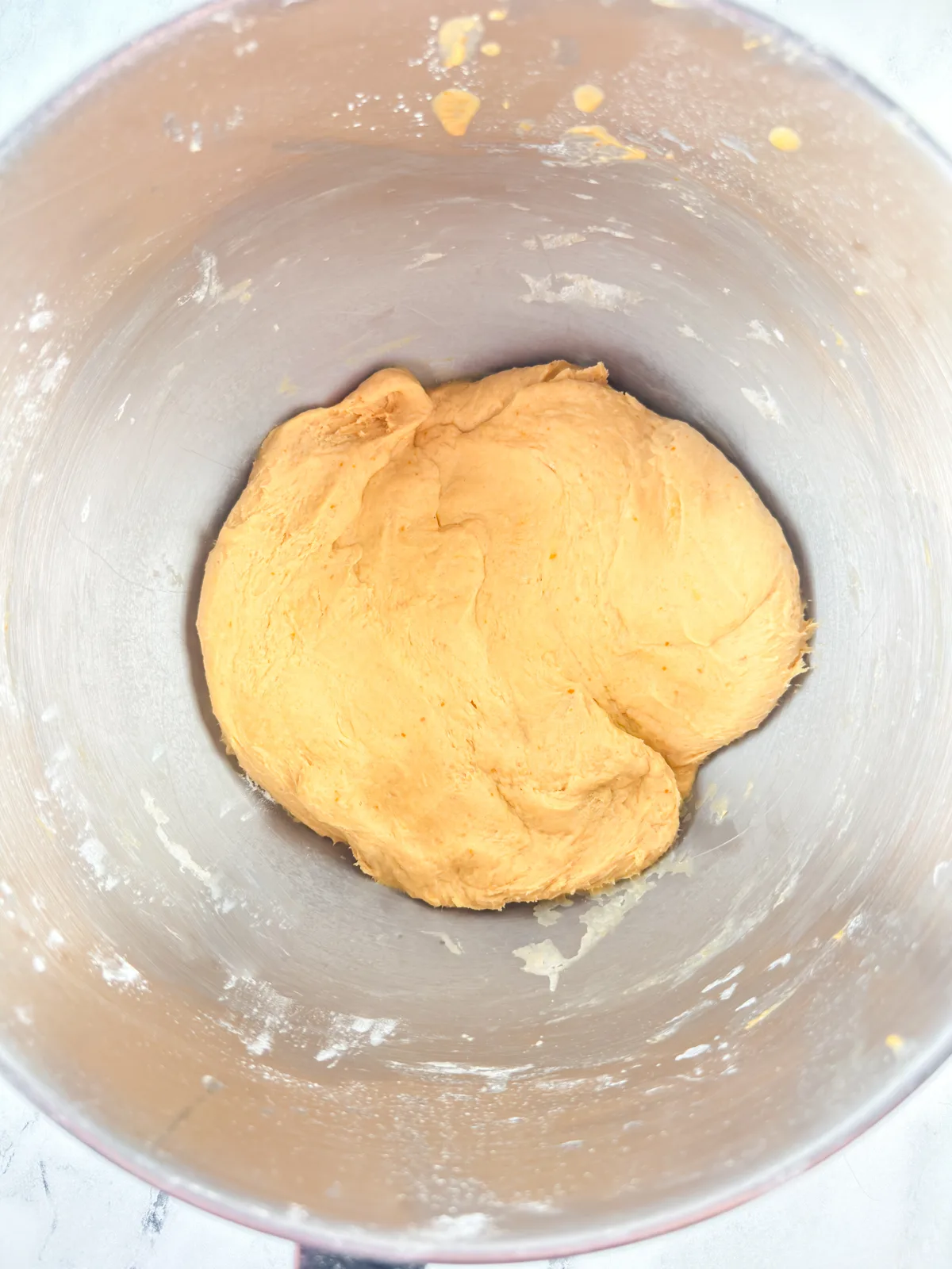 Kneaded pumpkin dinner roll dough in a stand mixer.