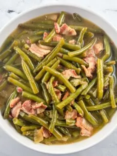 Southern smothered green beans in a white round bowl.